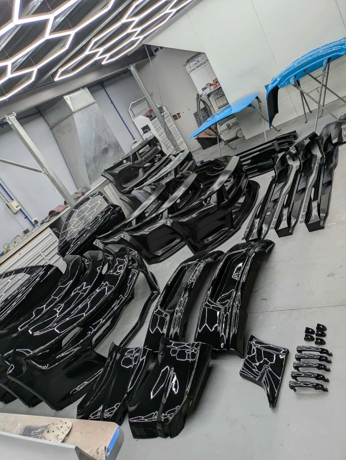 Gloss black painted body panels under workshop lighting
