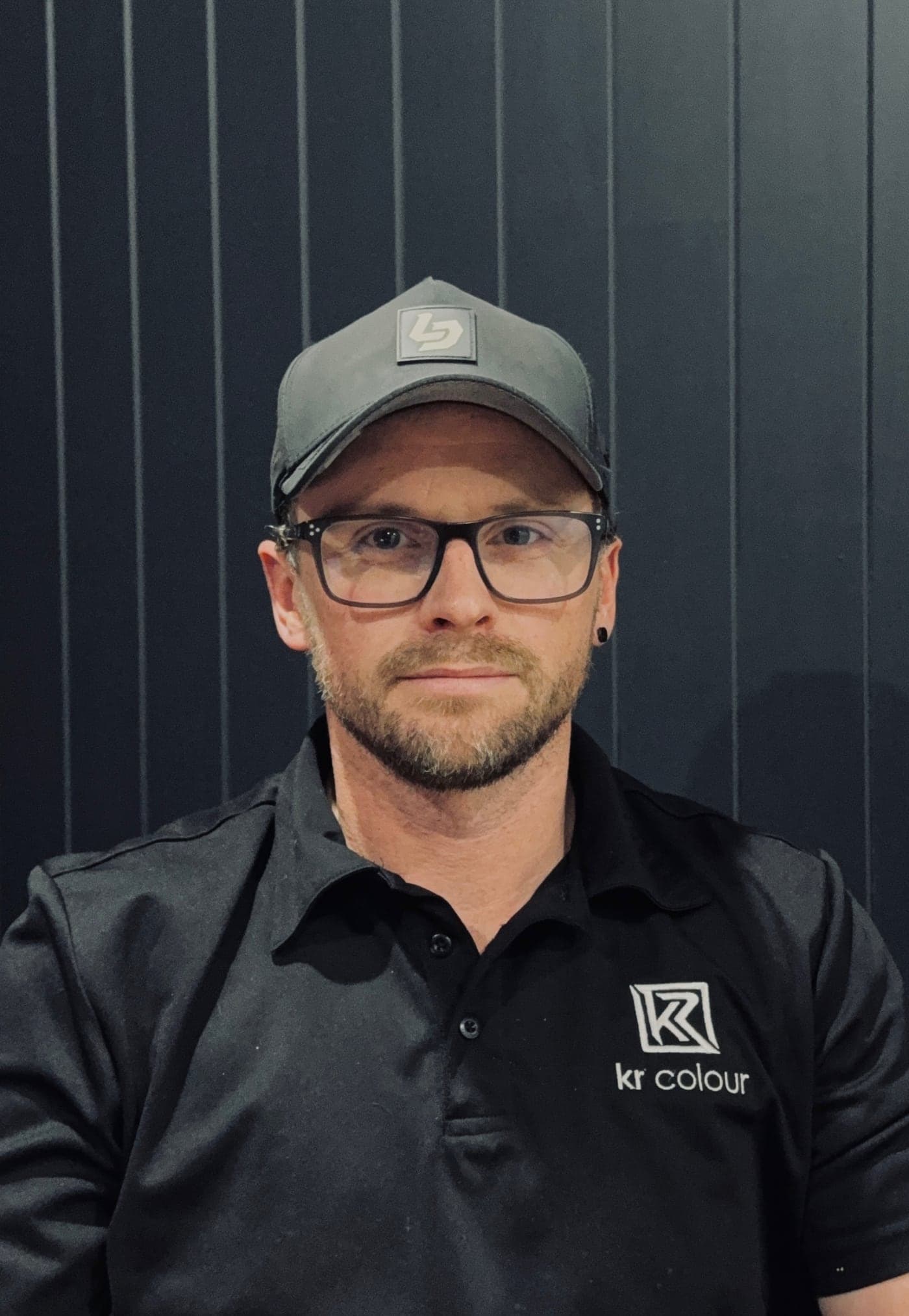 Kyle Rowell, owner of KR Colour, in a KR Colour polo at the workshop